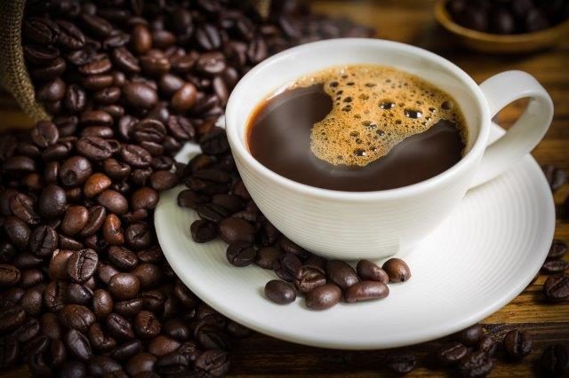 Cup of coffee with saucer and coffee beans